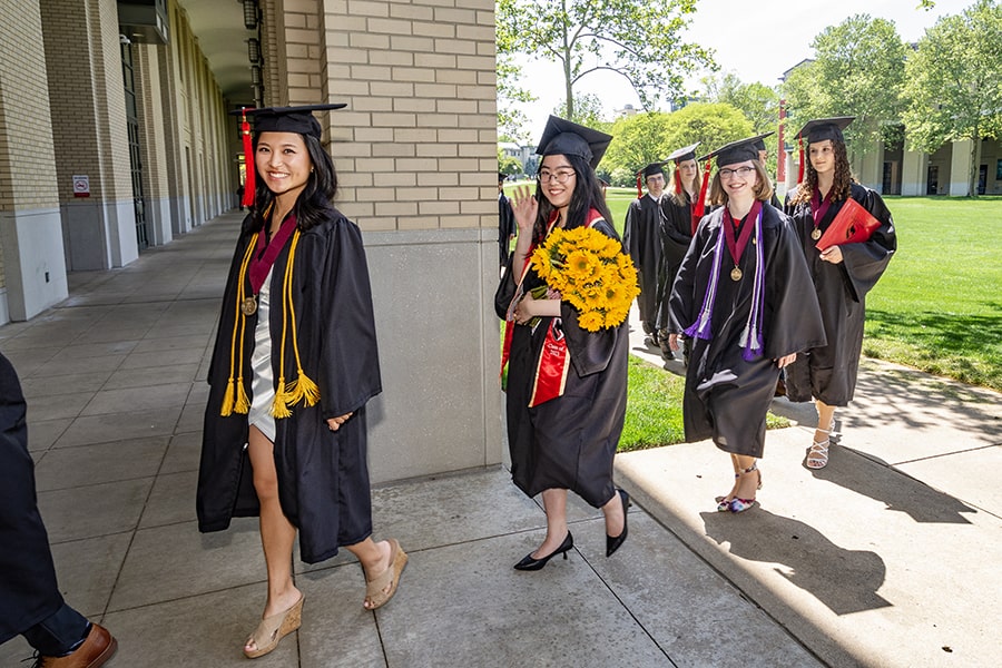 Students smile and wave as they enter the PBK initiation ceremony