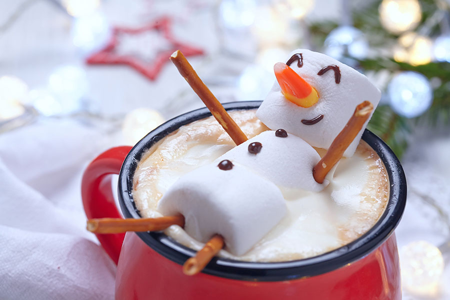 Marshmallow snowman floating in mug of hot cocoa