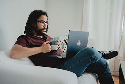 male student sitting casually working on an assignment for the masters in innovation online degree