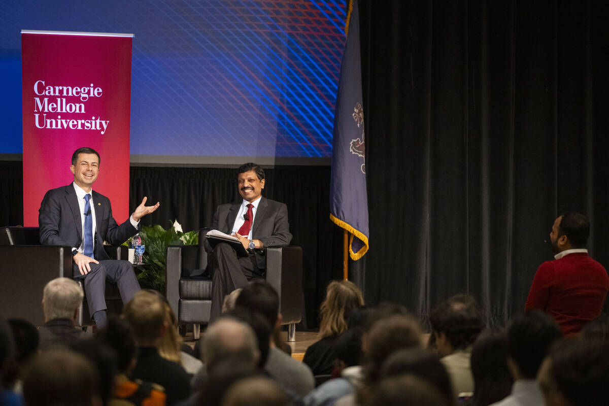 Pete Buttigieg and Raj Rajkumar talk during a Q&A.