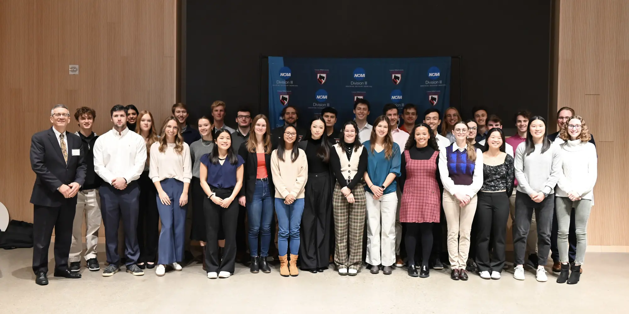 Jim Garrett standing with large group of student-athletes