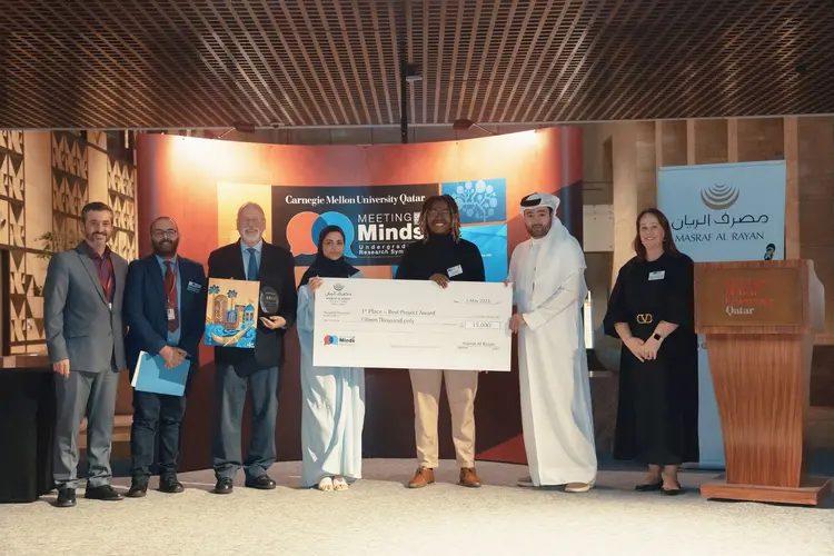 group of people on stage holding large check