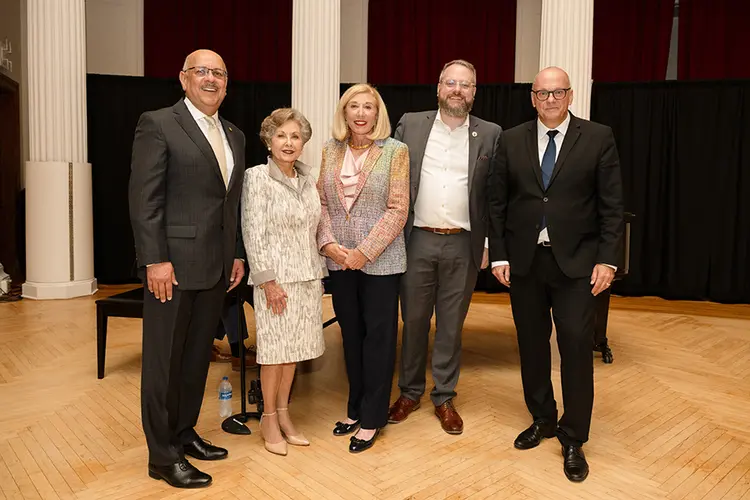 five people standing on a stage