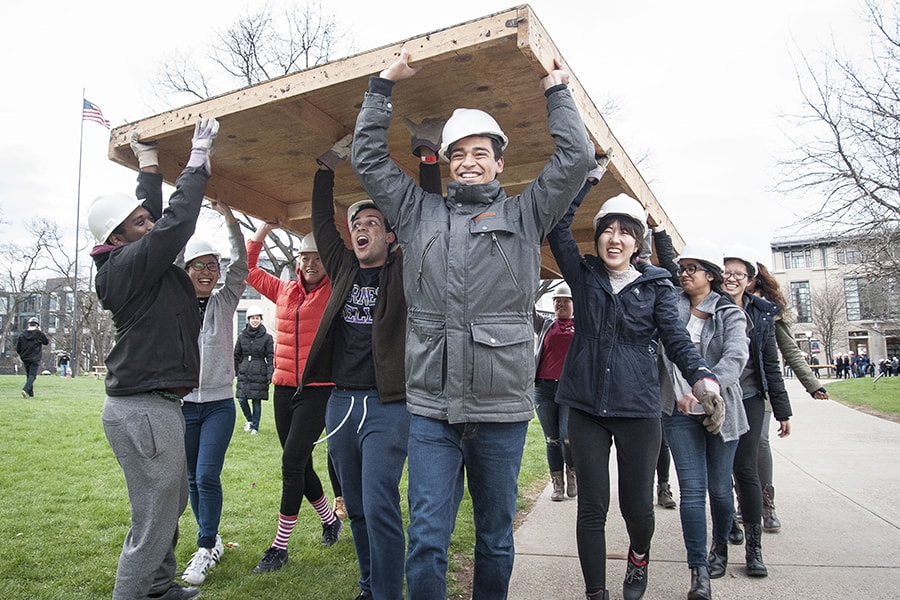 Image of students during carrying construction materials