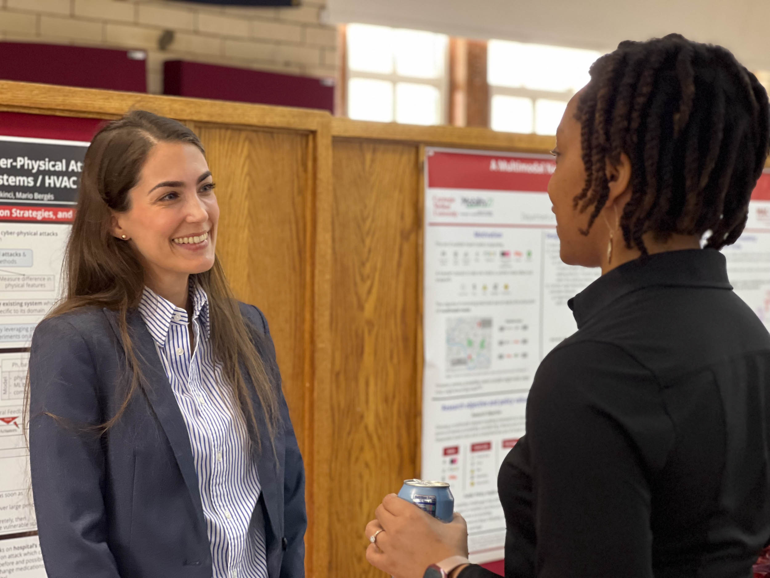 Professor Destenie Nock chats with guest at poster session
