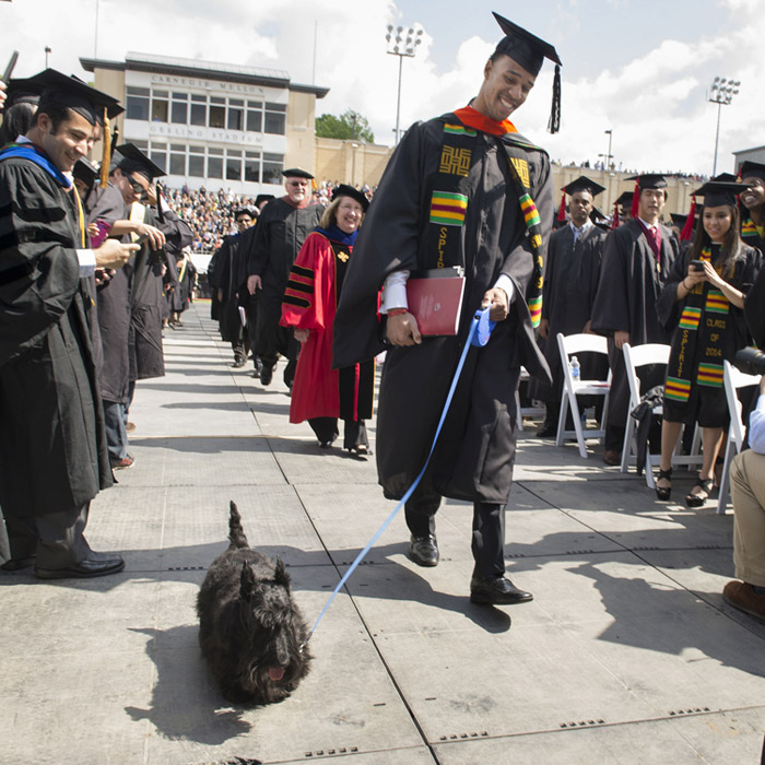 Scotty walking with new graduate at commencement