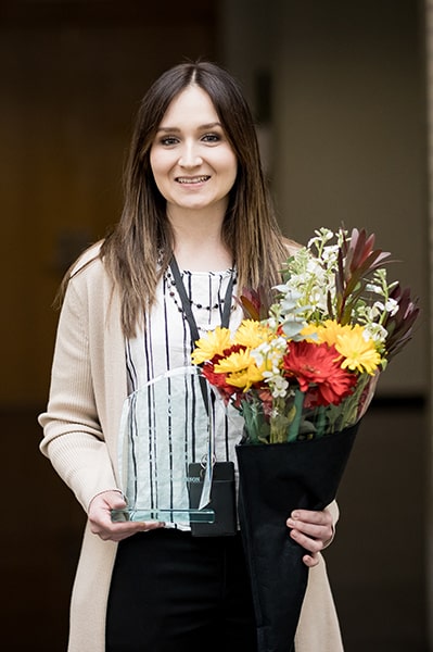 Ashley Christopherson poses with flowers and her award.