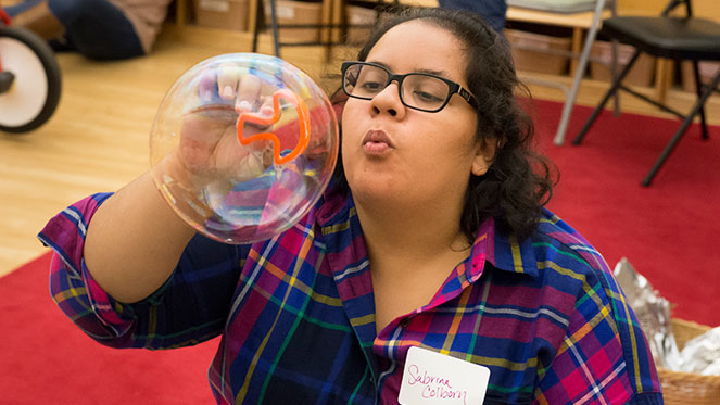 Sabrina Coborn, from the University Child Development Center, tests out classroom bubble activities with other PAUS educators. The recipe for Super Soap Solution was one of many methods shared.