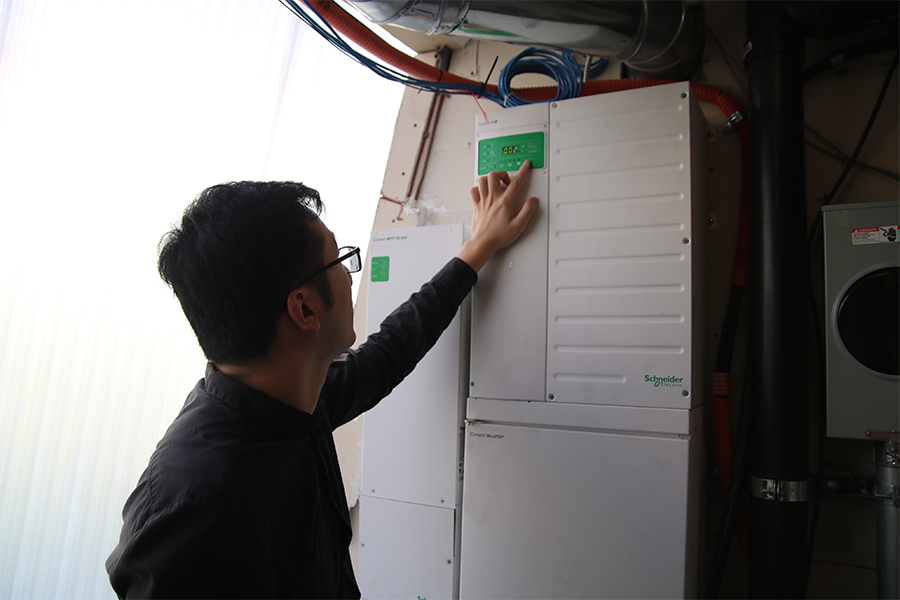 Carnegie Mellon University Engineering and Public Policy PhD student Guannan, who is part of the CMU SHINES research team, turns on a switch for the solar power inverter.
