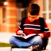 Child reading a book outside
