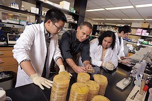 photo of Aaron Mitchell in lab with undergraduate students