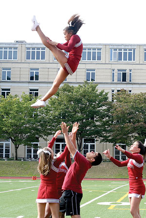 Paul Jasinto catching fellow cheerleader