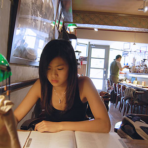 photo of Brooke Kuei reading in a coffee shop