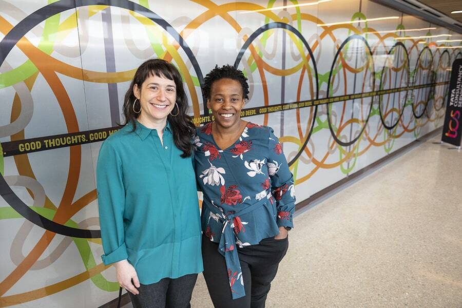 Two people in front of a mural