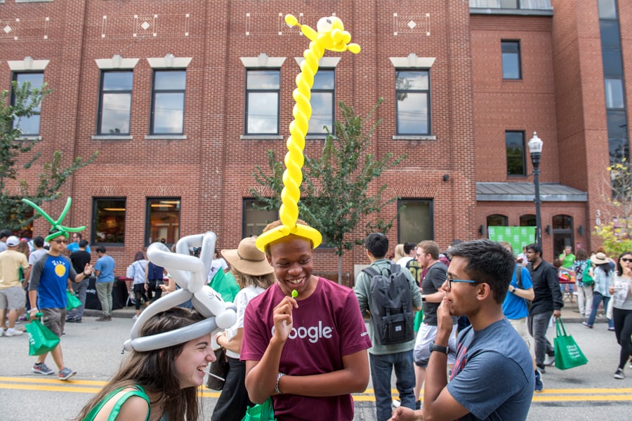 Image of first-year students with one wearing a very tall giraffe balloon hat