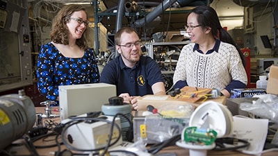 Image of three students talking together in a lab