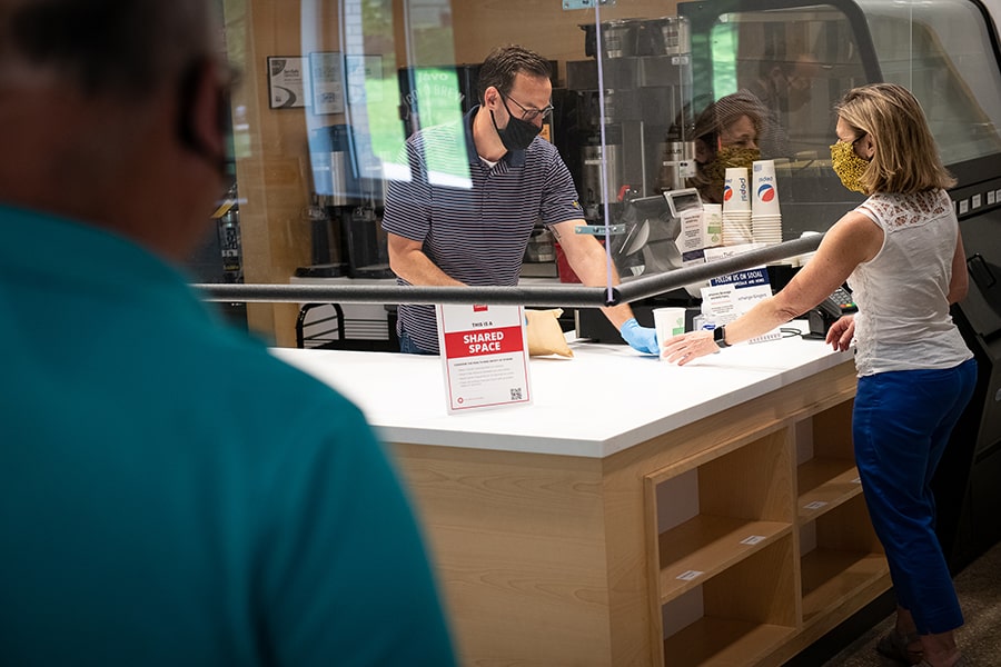 image of a dining cashier shielded by plexiglass