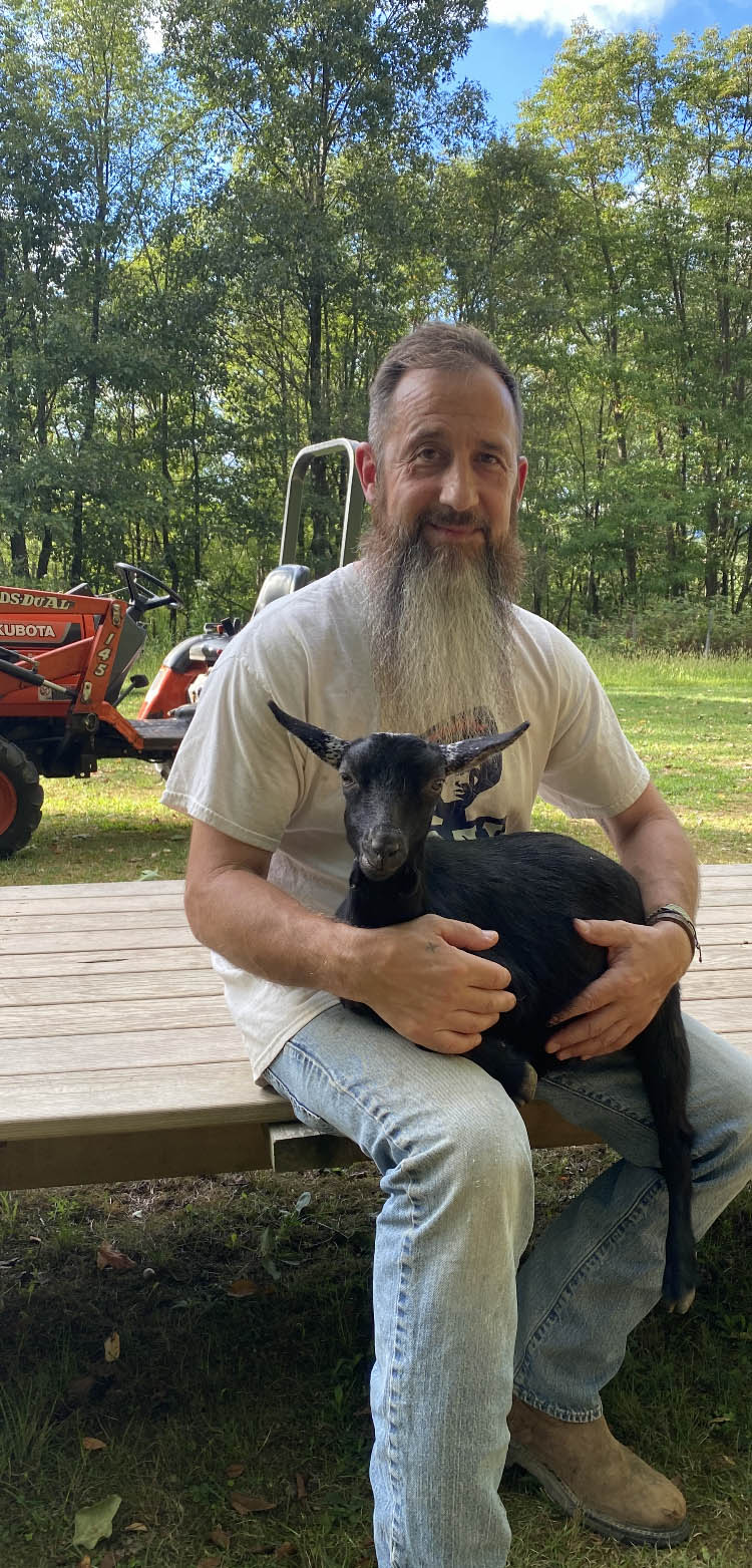 Bradley Travaglia holding Piper the goat