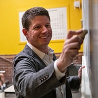 image of David Danks writing on a blackboard