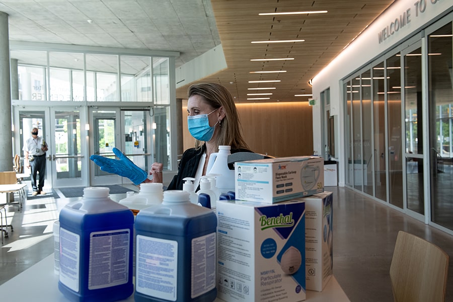 image of Charity Anderson putting on a glove with cleaning products in the foreground