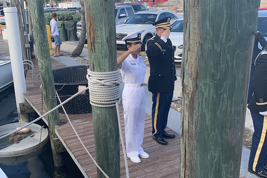 Eliana and her father saluting during a taps ceremony