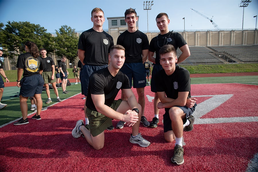 five midshipmen pose for a photo in the end zone