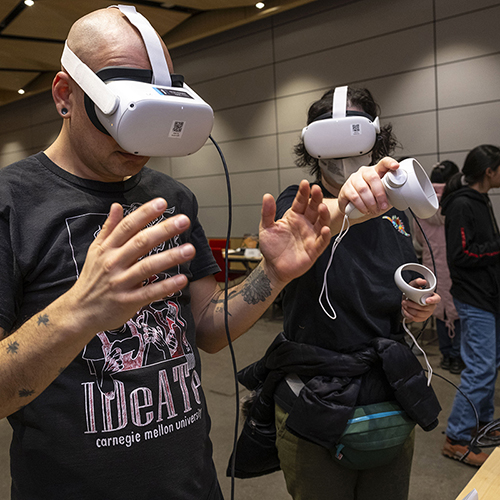 Two people wear virtual reality headsets