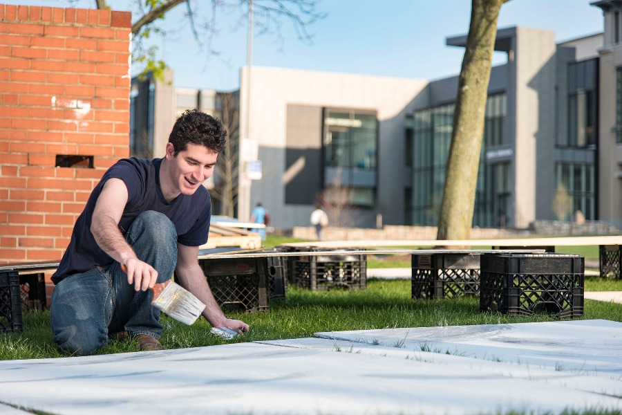 Carnegie Mellon student paints a Booth in preparation for Carnival