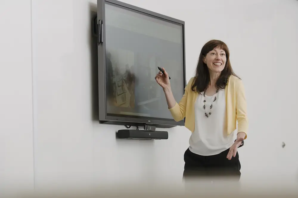 A CMU faculty member presenting in front of a smart TV