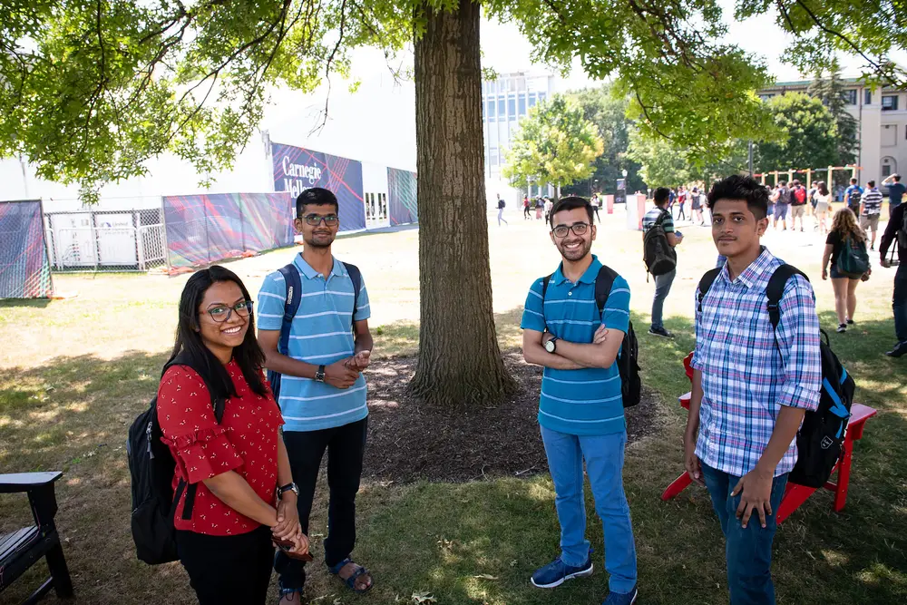 A diverse group of CMU students gathered outdoors on campus