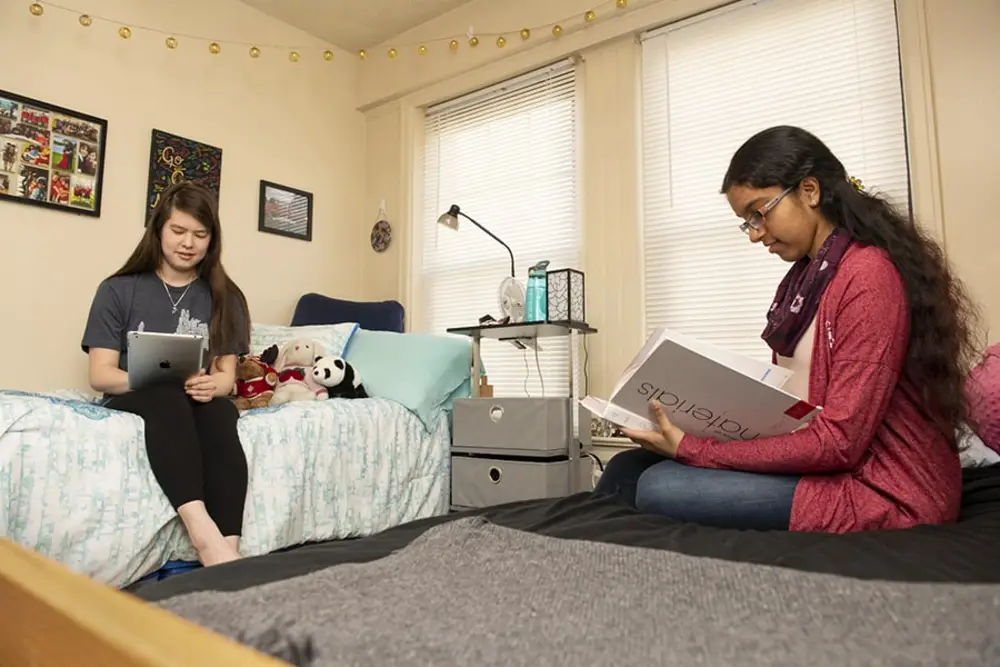 Two students reading/doing work in a CMU dorm room