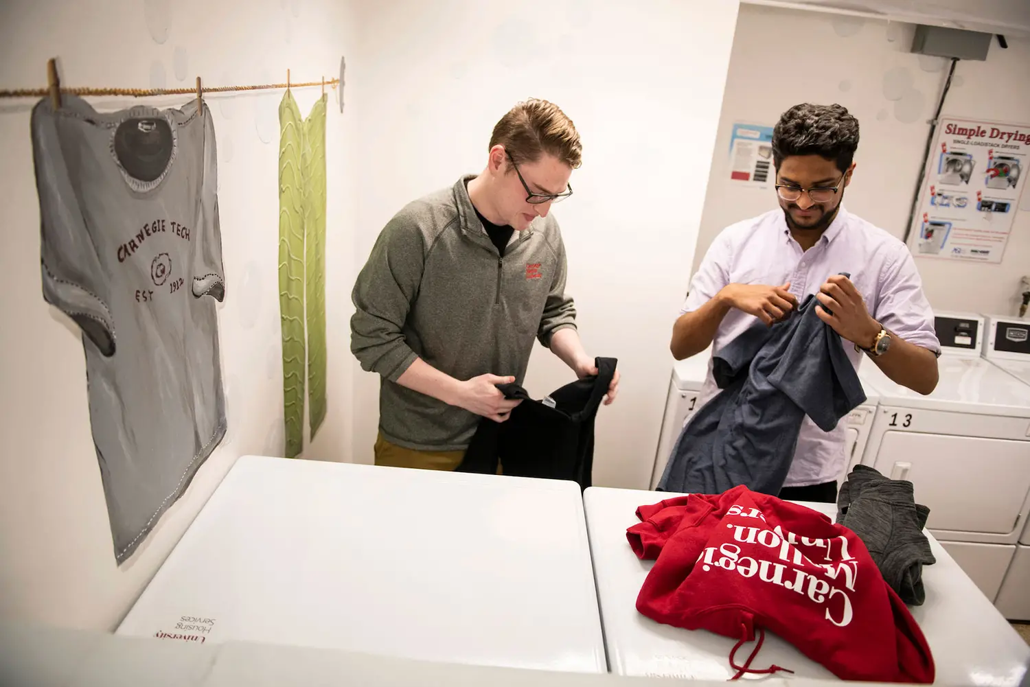 Two students doing their laundry in the dormitory.