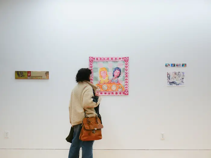 Student staring at a piece of art at the Frame Gallery