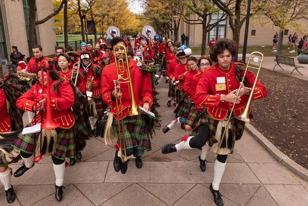 The Kiltie Band marching on campus during Homecoming