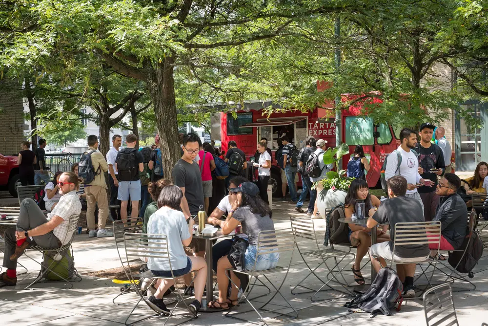 Outside, students lining up for the Tartan Express food truck and eating at café tables in the courtyard.