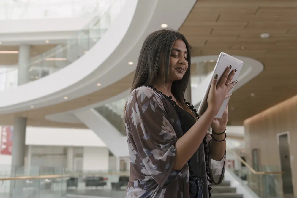 A student smiling and looking at her iPad