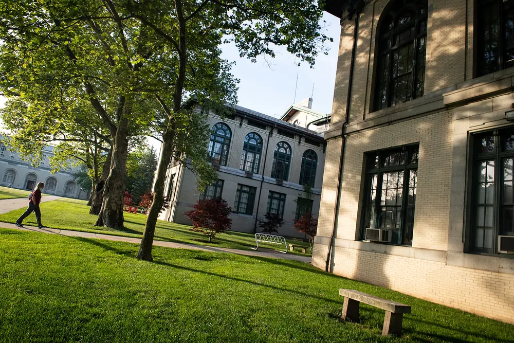 An individual walking outside on a path at CMU's campus