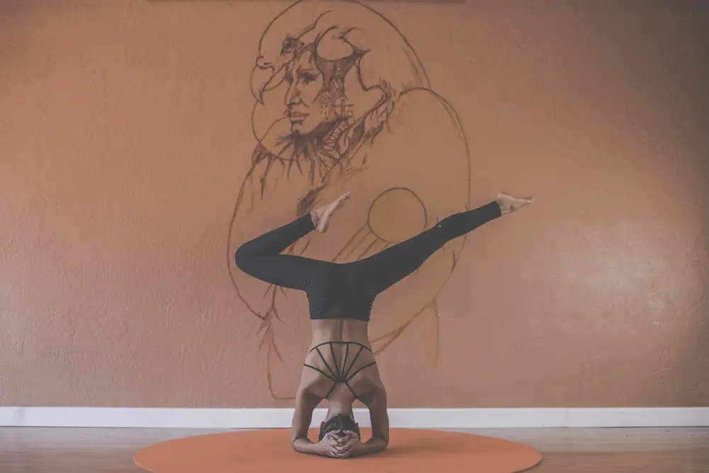 An individual doing a yoga headstand