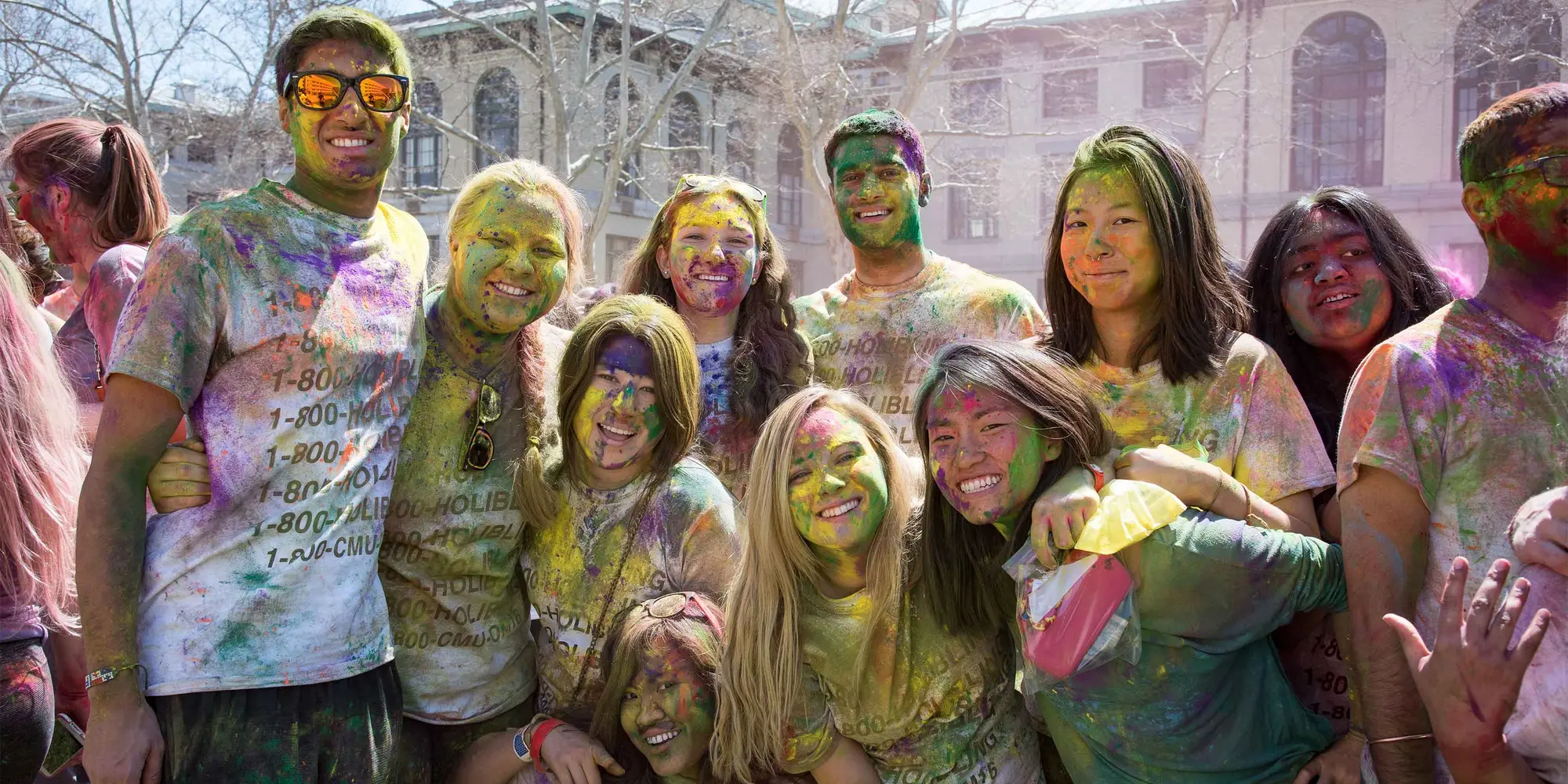 Group of students at Holi, covered in brightly colored pigment.