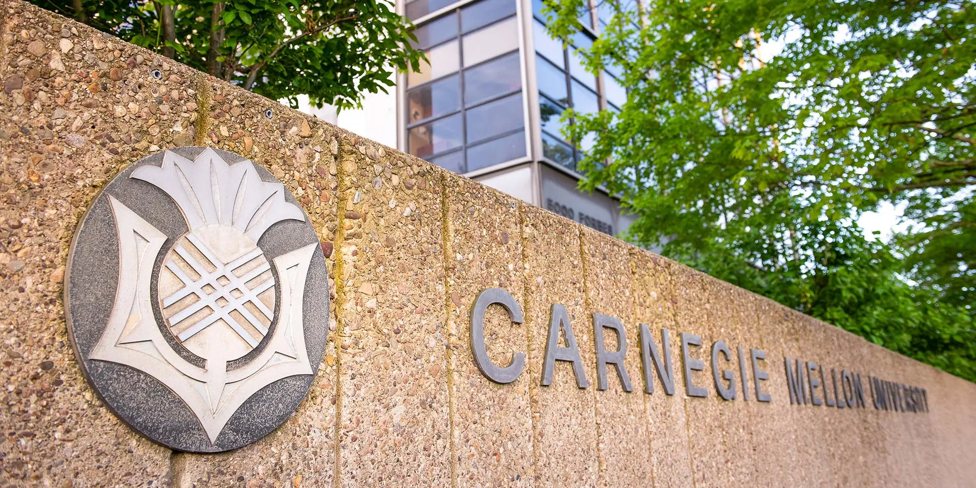 Wall at CMU with the university seal and wordmark.