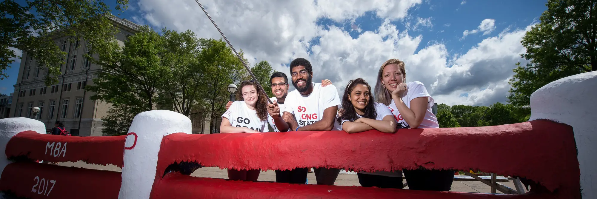 CMU ambassadors standing in front of The (recently painted) Fence.