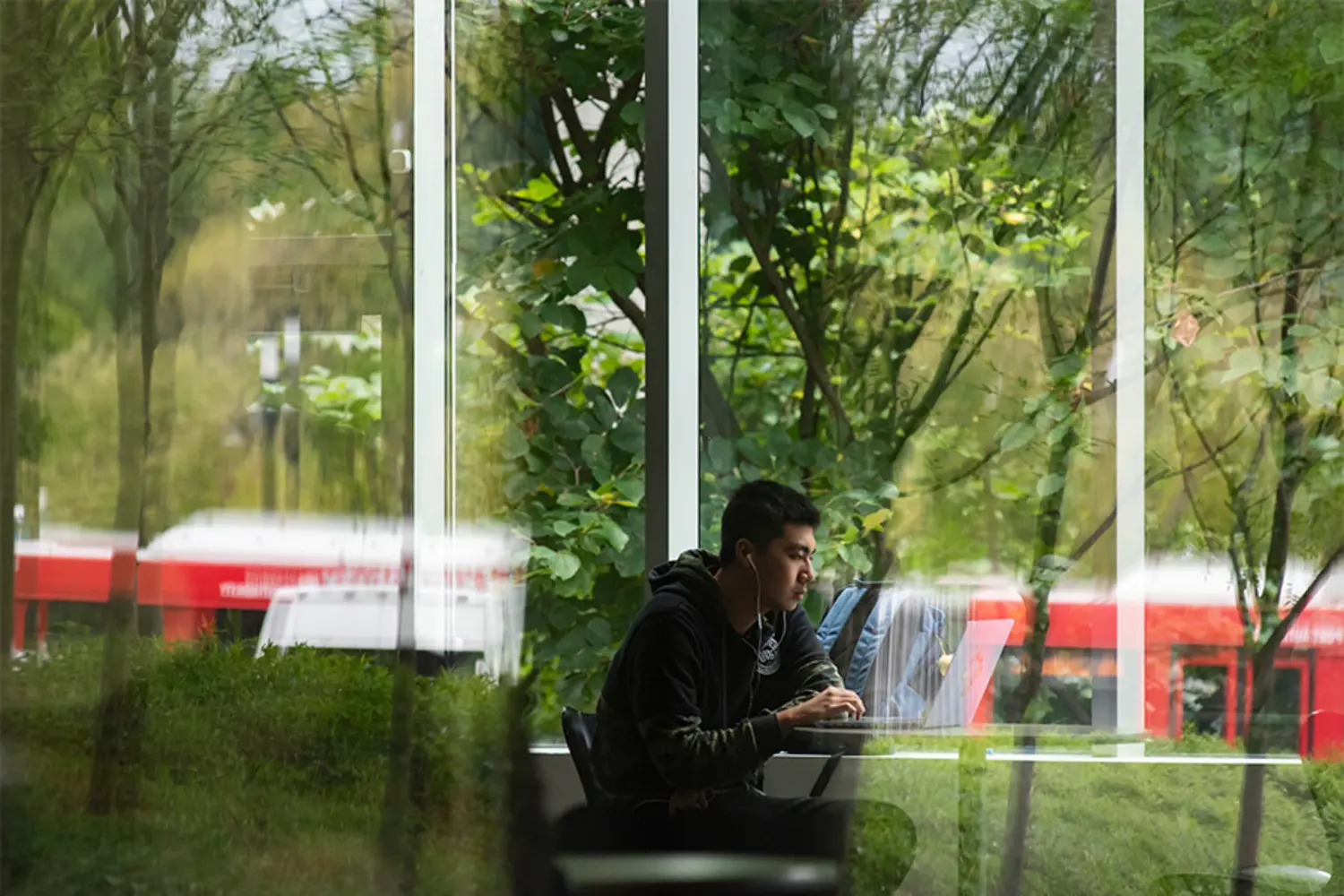 Looking through a window as a student works on a laptop.