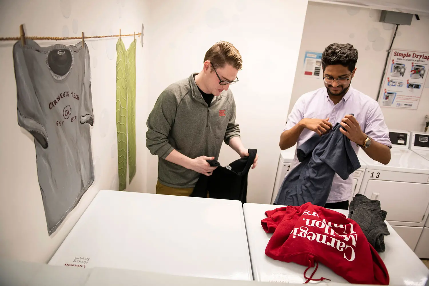 Two students doing their laundry in the dormitory.