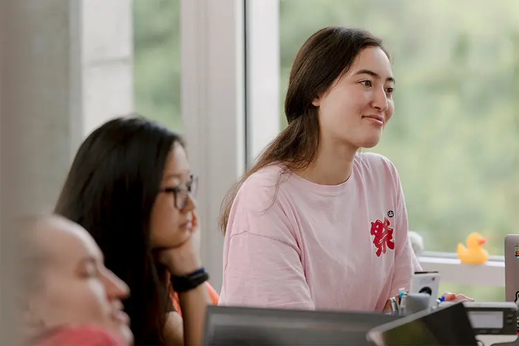 Student, happy and engaged in a lecture.