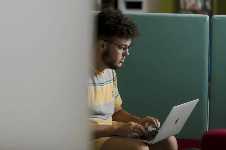 A student working on his Mac laptop