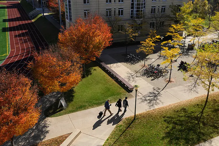 Students walking across campus in the fall.
