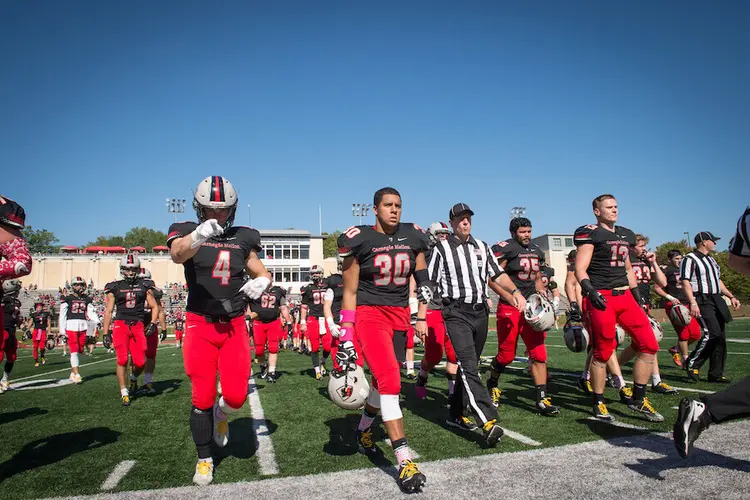 CMU football players exit the field