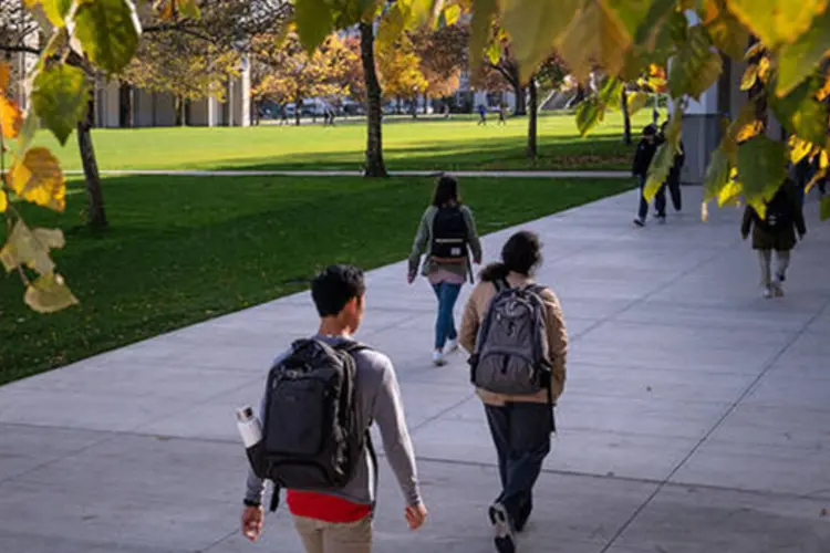 Students walking across campus in autumn.