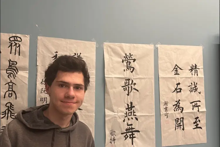 Peter standing in front of Chinese calligraphy posters