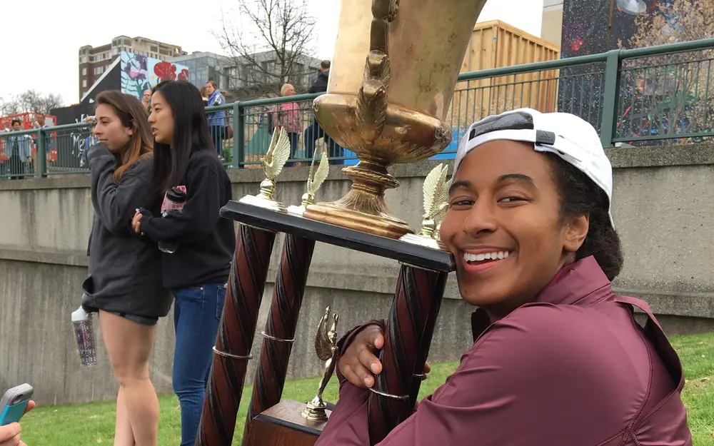 Student hugging trophy